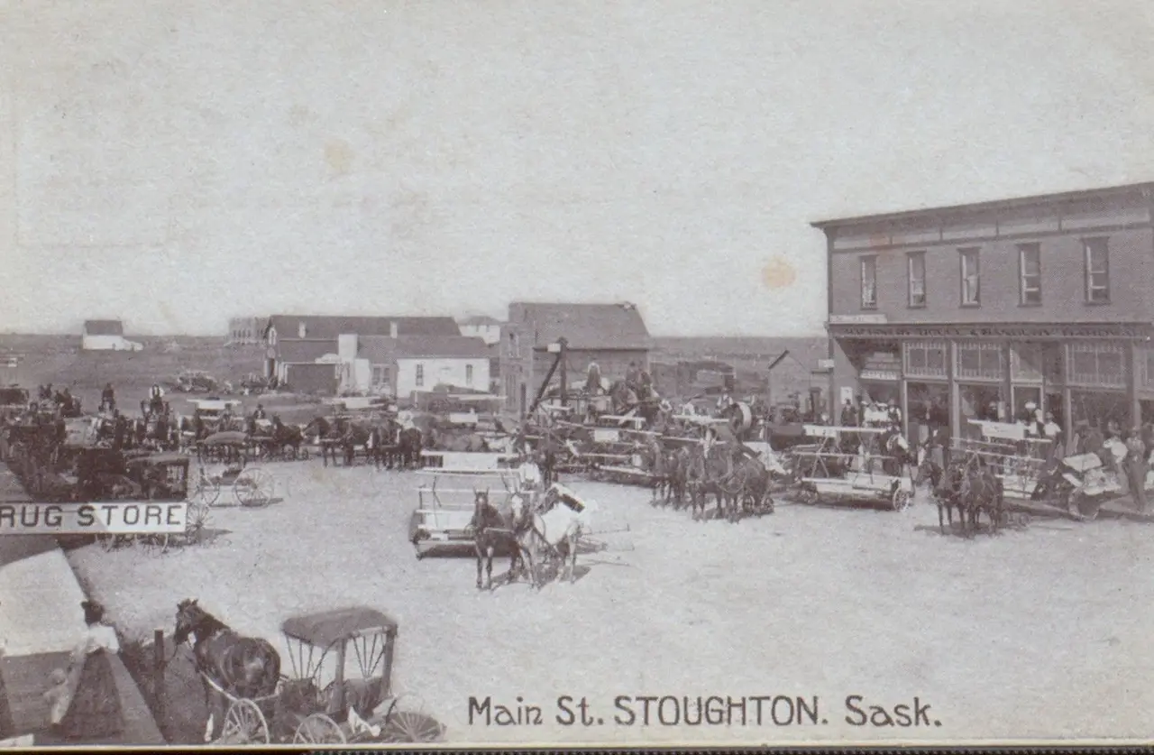 Main Street, Stoughton, with horse-drawn wagons and threshing equipment, about 1910