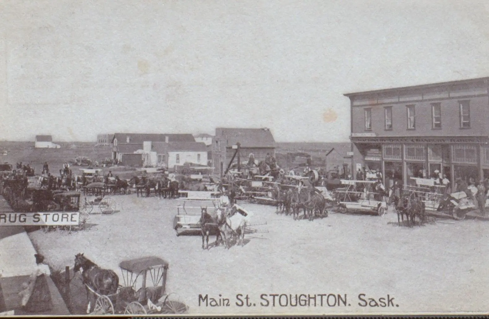 Main Street, Stoughton, with horse-drawn wagons and threshing equipment
